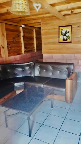 - un canapé en cuir noir dans une chambre dotée de murs en bois dans l'établissement Yatzil, à La Trinitaria