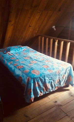 a bed with a blue blanket on top of it at Yatzil in La Trinitaria