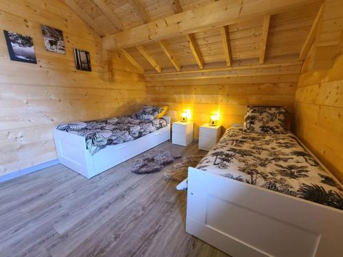 um quarto com duas camas num chalé de madeira em Gîte Girmont-Val-d'Ajol, 4 pièces, 6 personnes - FR-1-589-472 em Girmont-Val-dʼAjol