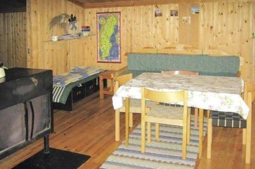 een keuken met een tafel en stoelen in een kamer bij Einfache Holzhütte für das wahre Naturerlebnis am See in Ytterhogdal