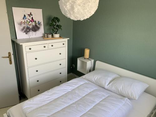 a bedroom with a white bed and a dresser at Appartement F2 avec balcon, à 2 pas de la plage, parking privé, animaux admis - FR-1-482-113 in Fort-Mahon-Plage