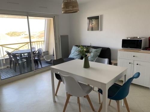 une cuisine et un salon avec une table et des chaises dans l'établissement Appartement F2 avec balcon, à 2 pas de la plage, parking privé, animaux admis - FR-1-482-113, à Fort-Mahon-Plage