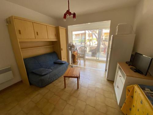 salon z niebieską kanapą i stołem w obiekcie Studio Cabine 4 Pers, Terrasse, Parking Privé, Proche Plage et Commerces, La Franqui - FR-1-81-585 w mieście Leucate