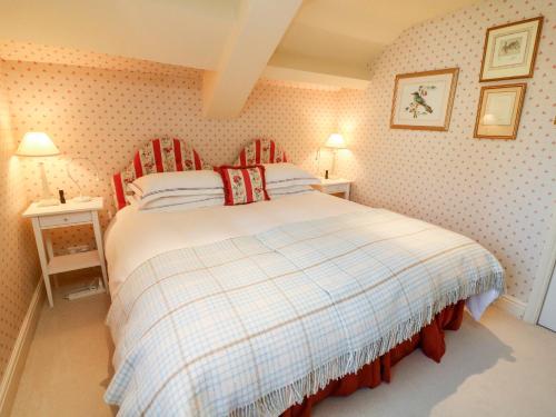 a bedroom with a bed with a plaid blanket at The Garden Rooms Lawkland in Austwick