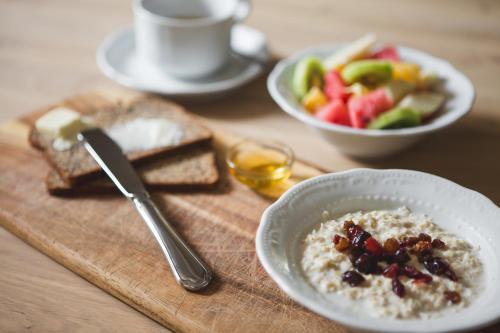 a bowl of oatmeal and a bowl of fruit and toast at Palazzo Radomiri Heritage Boutique Hotel in Kotor