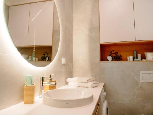 a white bathroom with a sink and a mirror at Comfortable apartment overlooking the seaside beach in Niechorze in Niechorze