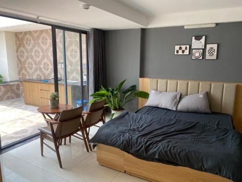 - une chambre avec un lit, une table et des chaises dans l'établissement Ngọ house, à Hô-Chi-Minh-Ville