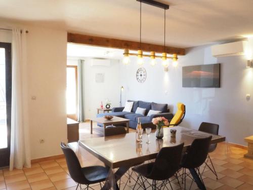 un salon avec une table et un canapé bleu dans l'établissement House in Vaison-la-Romaine with Pool, à Vaison-la-Romaine