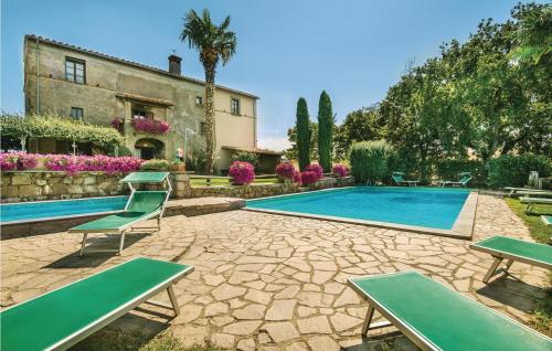 a swimming pool with green chairs and a building at Villa Arzilla in Vitorchiano