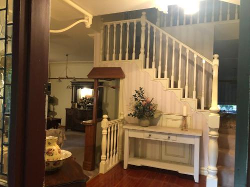 a staircase in a house with a white stair case at Hawk's Nest Bed & Breakfast in Bathurst