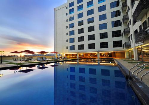 ein Hotel mit einem Pool vor einem Gebäude in der Unterkunft Ming Greenage Suite 明绿时代套房 @Kota Kinabalu 亚庇市中心 in Kota Kinabalu