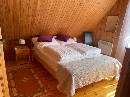 1 dormitorio con 1 cama en una habitación de madera en DOM Z BALI Villa Bajkowy Dom en Dźwierzuty