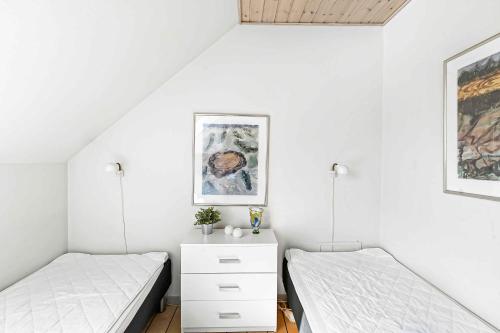 two beds in a room with white walls at Brddegade 14, 3760 Gudhjem in Gudhjem