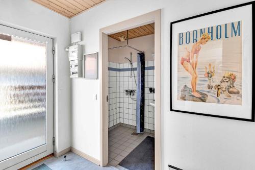 a bathroom with a shower and a picture on the wall at Brddegade 14, 3760 Gudhjem in Gudhjem