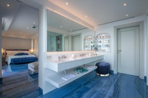 a bathroom with a sink and a bed in a room at Hotel Grotta Palazzese in Polignano a Mare
