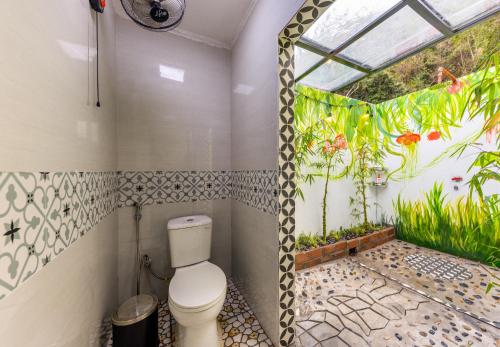 a bathroom with a toilet in a room with a window at Cat Ba Spring Garden Private House in Cat Ba