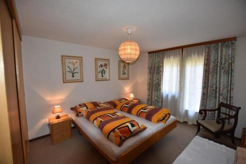 um quarto com 2 camas e um lustre em Ferienwohnung mit wunderschöner Aussicht em Krattigen