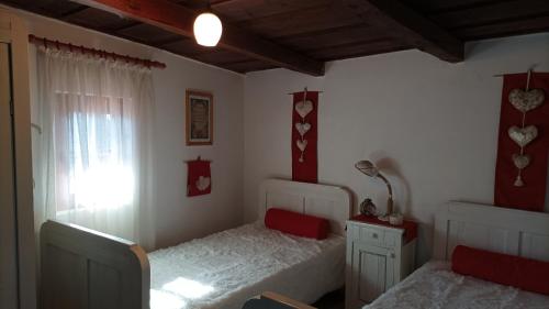 1 dormitorio con 2 camas y ventana en Meselak, en Ocna de Sus
