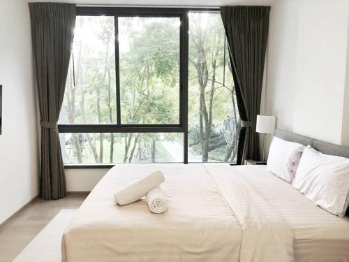 1 dormitorio con 1 cama grande y ventana grande en The Valley byJT, en Ban Huai Sok Noi