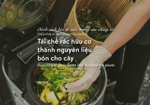 a woman is cooking a salad in a pan at Amanaki Saigon Boutique Hotel in Ho Chi Minh City