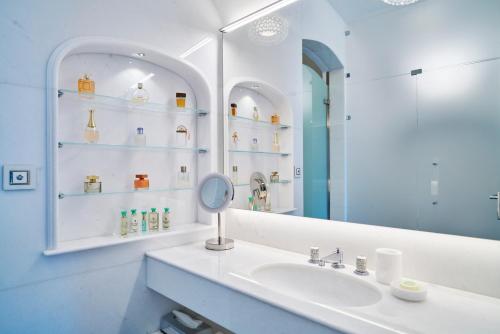 a bathroom with a sink and a mirror at Hotel Grotta Palazzese in Polignano a Mare