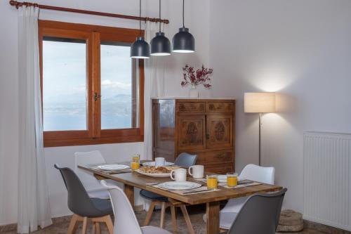 comedor con mesa de madera y sillas en Galani Vacation House, en Likotinaréa