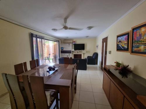 a dining room and living room with a table and chairs at Casa en condominio a 3 minutos del Aeropuerto in Luque