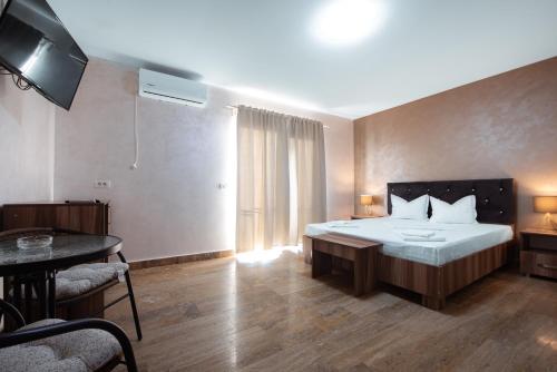 a bedroom with a large bed and a table and a tableablish at La Dudu in Vama Veche