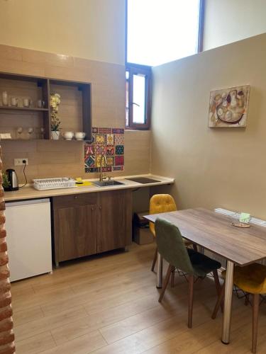 a kitchen with a wooden table and a table and chairs at Historic Apartments "1868 Tbilisi" Best Location in Tbilisi City