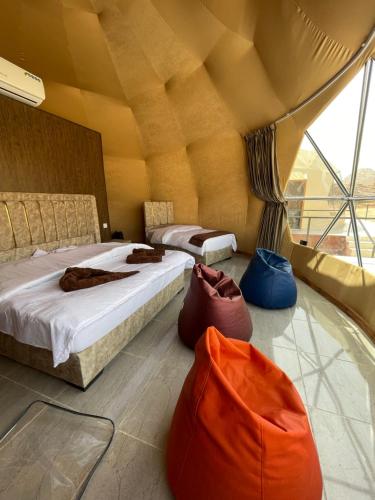 a room with two beds and two bags on the floor at Adel rum camp bubbles in Wadi Rum