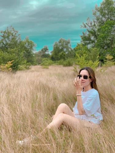 a woman sitting in a field of tall grass at Damnak Borey Resort in Kampot