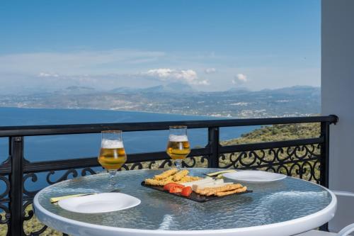 una mesa con dos copas de vino y un plato de comida en Galani Vacation House, en Likotinaréa