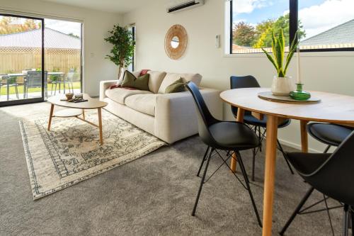 a living room with a table and a couch at Riccarton 2 bed 1 bath w/garage in Christchurch