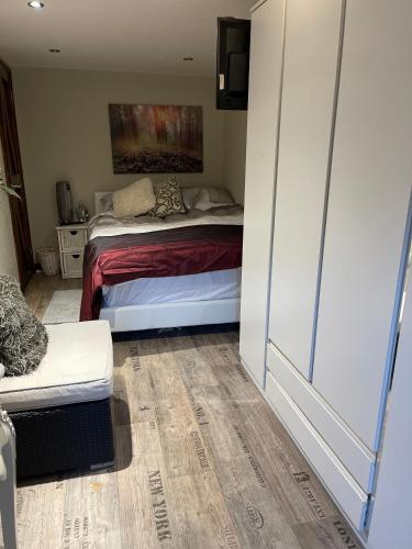 a bedroom with a bed and a couch in a room at South Lodge House in Dormans Land