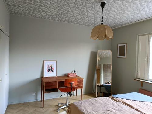 Schlafzimmer mit einem Schreibtisch, einem Bett und einem Spiegel in der Unterkunft Hieno kaksio keskustassa rauhallisella alueella in Lovisa
