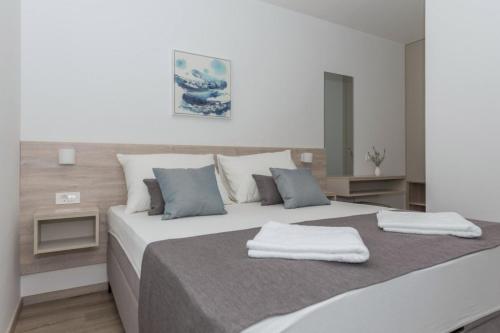 a bedroom with a bed with two towels on it at Apartments Mari - 40m from the beach in Makarska