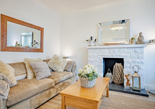 a living room with a couch and a fireplace at Argraig in Abersoch