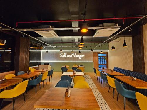 a dining room with wooden tables and yellow chairs at Hotel Starway in Balasore