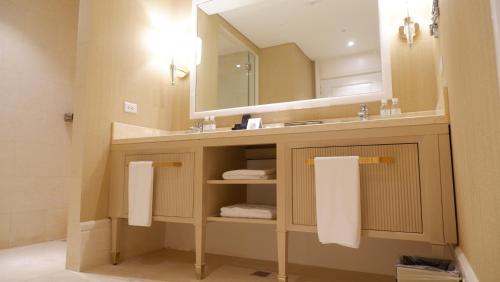 a bathroom with a sink and a mirror and towels at Royce Hotel & Casino in Clark