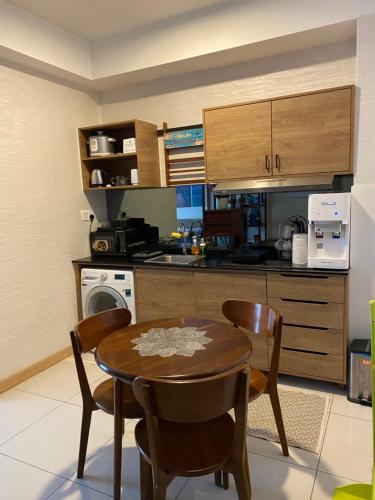 uma cozinha com mesa e cadeiras num quarto em Timurbay Seafront Residence aRRayyan Suites em Kuantan