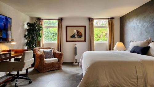 a bedroom with a bed and a desk and chairs at Casa Tamayo in Mexico City