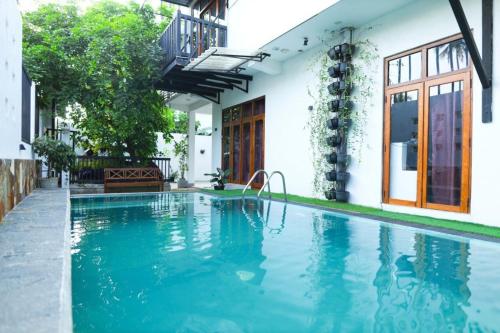 una piscina frente a una casa en Blooming Holiday Resort, en Anuradhapura
