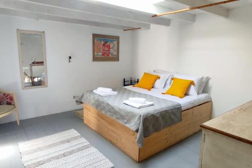 une chambre avec un grand lit avec des oreillers jaunes dans l'établissement Town House near Old Town with Rooftop Jacuzzi, à Rhodes