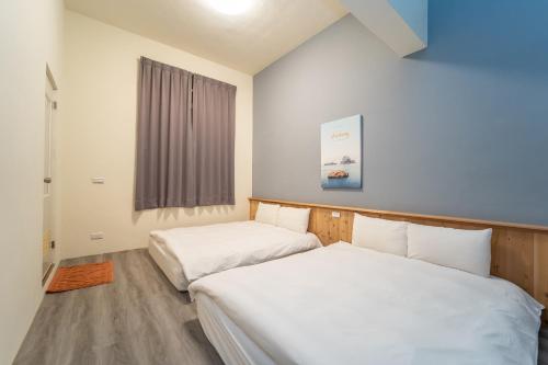a bedroom with two beds and a window at Qilin Valley in Puli