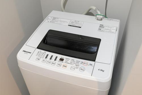 a microwave oven sitting on top of a refrigerator at Shinosaka private house for 16ppl in Osaka