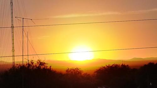 una puesta de sol con la puesta de sol en la distancia en Hotel Monis, en San Rafael de las Torres