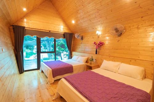 a bedroom with two beds in a wooden cabin at Cô Tô Lương Chi in Quang Ninh