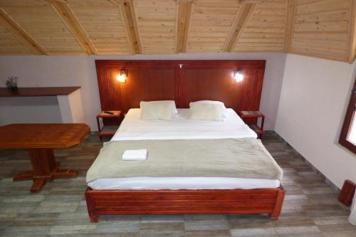 a bedroom with a large bed and a desk at Etno hotel Balasevic Rtanj in Boljevac