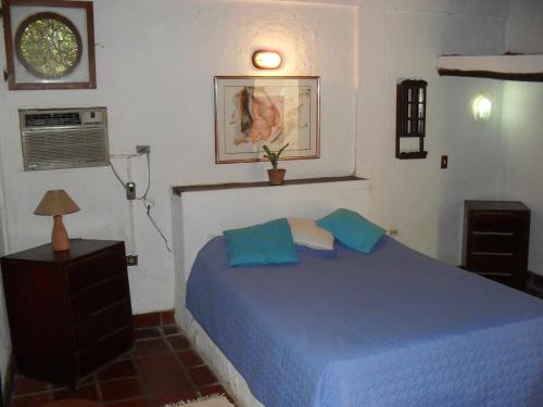 ein Schlafzimmer mit einem blauen Bett in einem Zimmer in der Unterkunft Posada la Arcadia in Pedro Gonzalez
