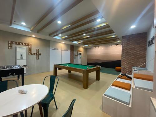 a room with a pool table and tables and chairs at Wjbca Staycation in Tagaytay